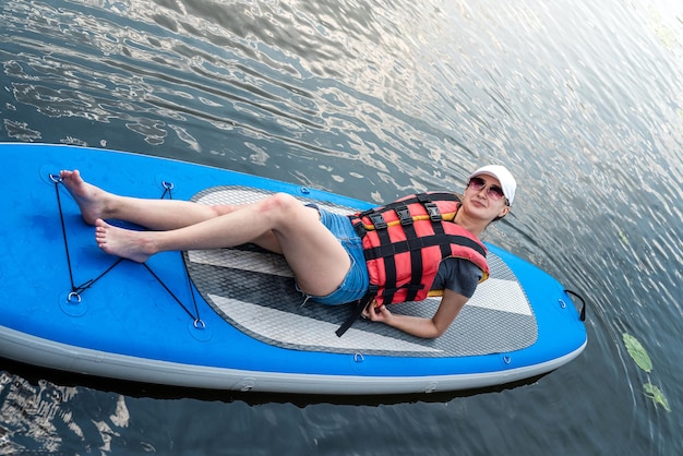 Pretty slim woman relax on sup board in summer time sea adventure freedom