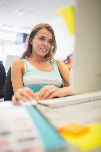 Foto ragazza sorridente graziosa che fa assegnazione nel centro di calcolo