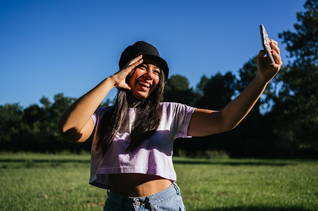 Pretty smiling girl taking a selfie.