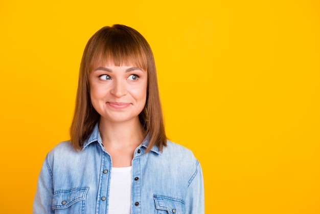 Pretty smiling joyfully female with fair hair dressed casually looking with satisfaction at camera isolated against blank studio wall