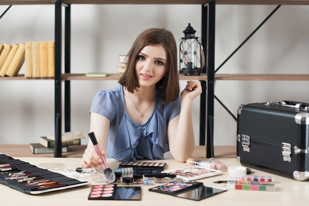 Pretty smiling make-up artist at workplace