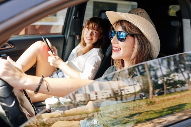 Foto donna abbastanza sorridente alla guida di auto