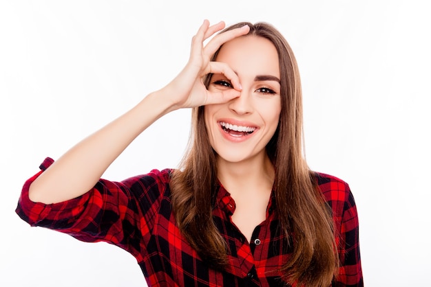 Giovane donna abbastanza sorridente che fa monocolo con le dita