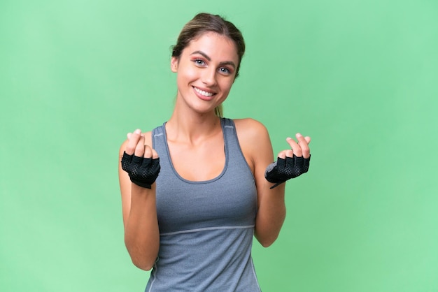 Pretty Sport Uruguayan woman over isolated background making money gesture