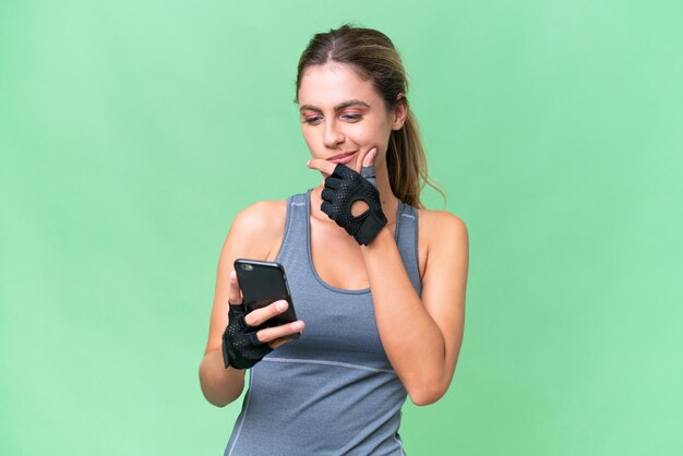 Pretty Sport Uruguayan woman over isolated background thinking and sending a message