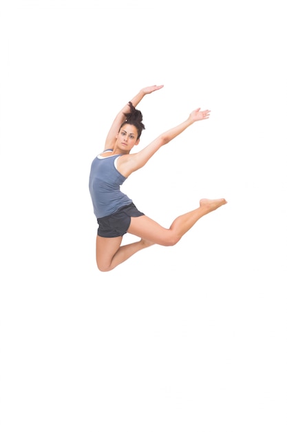 pretty sporty brunette jumping in the air with arms up