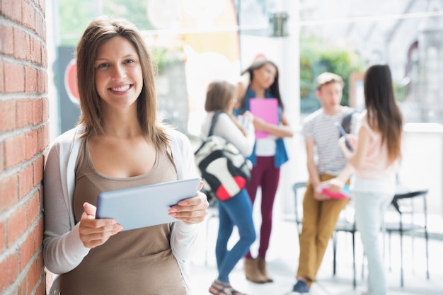 Pretty student smiling and holding tablet