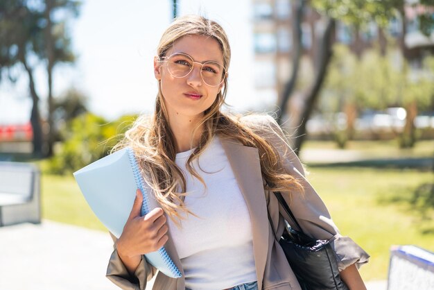 Photo pretty student uruguayan woman at outdoors with sad expression