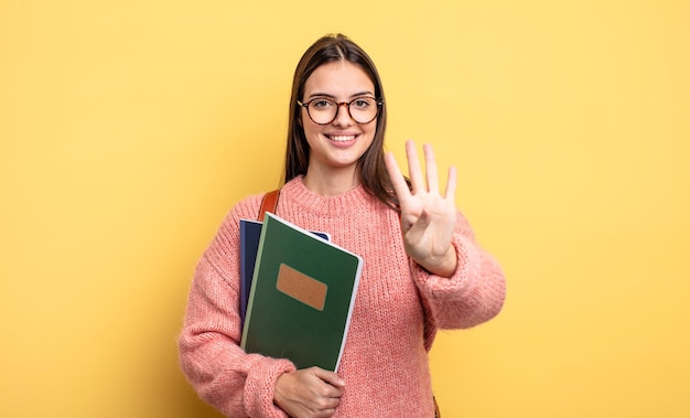 pretty student woman smiling and looking friendly, showing number four