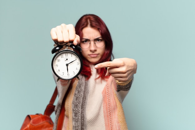 Photo pretty student woman with an alarm clock