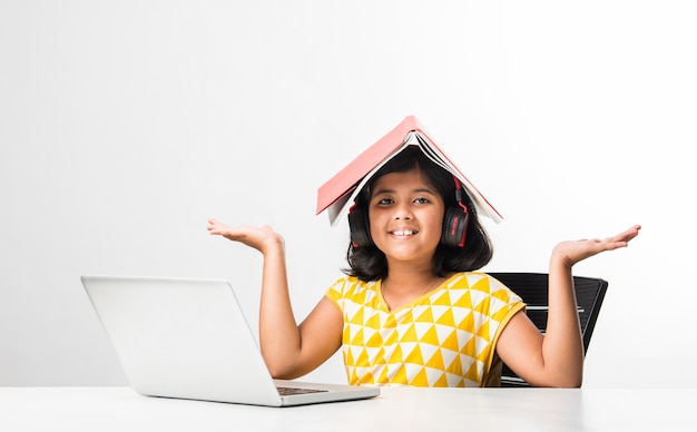 Pretty stylish Indian asian schoolgirl studying attending online lesson at home