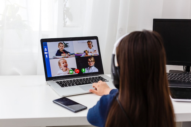 Pretty stylish schoolgirl studying homework math during her online lesson at home, social distance during quarantine, self-isolation, online education concept, home schooler
