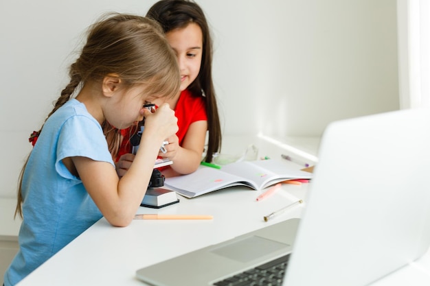 Pretty stylish schoolgirls studying during her online lesson at home, social distance during quarantine, self-isolation, online education concept