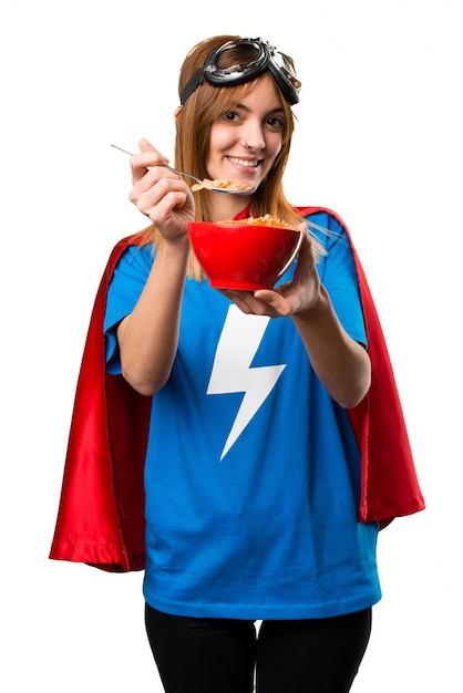 Pretty superhero girl eating cereals from a bowl