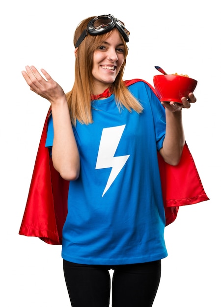 Pretty superhero girl eating cereals from a bowl