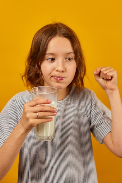 牛乳の新鮮なガラスを持つかなり十代の女の子の子供