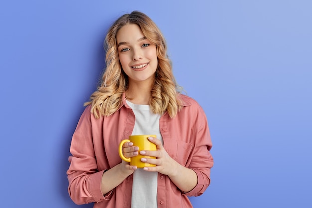 Pretty teen girl drinking coffee or tea