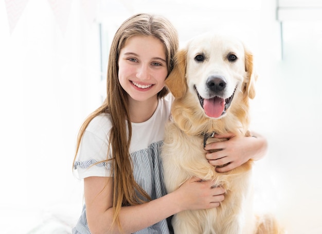 Pretty teenage girl hugging beautiful dog