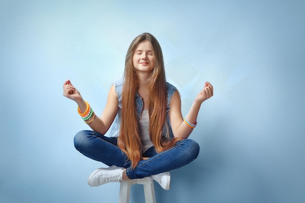 Pretty teenager girl posing on color background