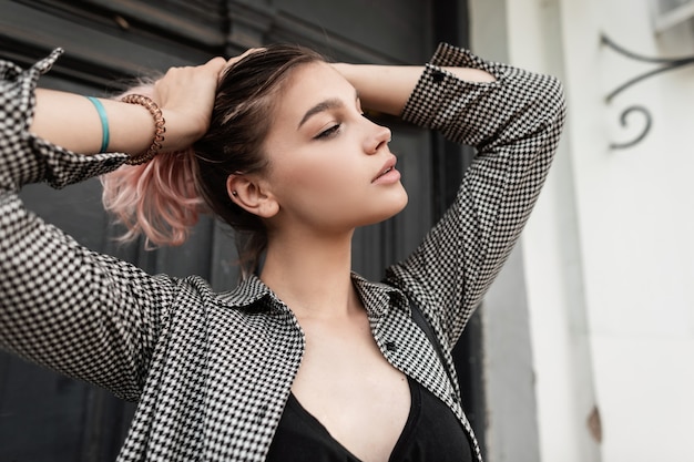 Bella ragazza adolescente con i capelli rosa in una camicia a quadri vintage alla moda per strada