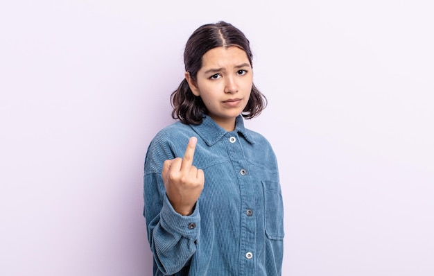 Pretty teenager woman feeling angry, annoyed, rebellious and aggressive, flipping the middle finger, fighting back