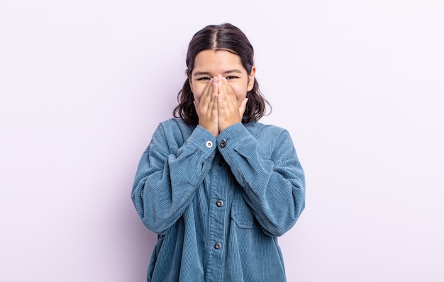 Pretty teenager woman looking happy, cheerful, lucky and surprised covering mouth with both hands