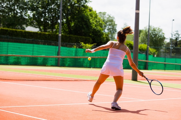 Pretty tennis player hitting ball