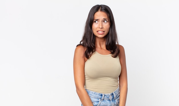 Photo pretty thin hispanic woman looking worried,panicking and clenching teeth