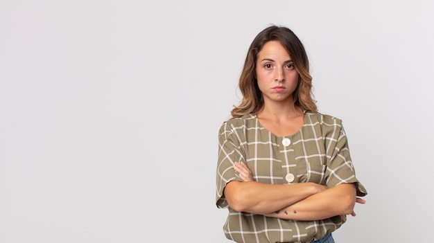 Pretty thin woman feeling displeased and disappointed, looking serious, annoyed and angry with crossed arms