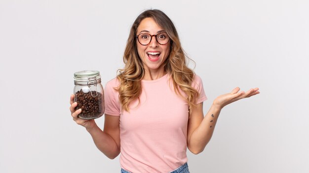 Pretty thin woman feeling happy, surprised realizing a solution or idea and holding a coffee beans bottle