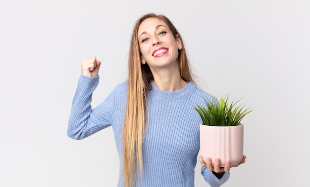 Pretty thin woman holding a decorative house plant