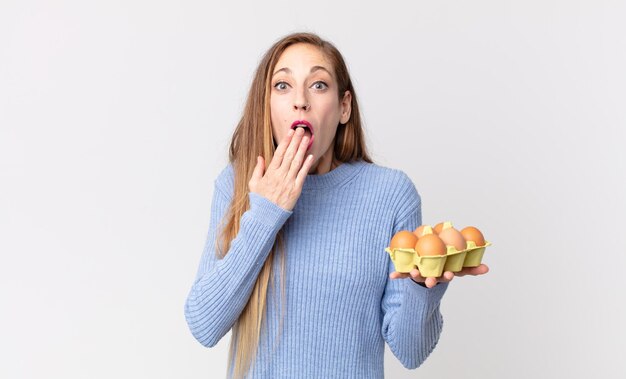 Donna abbastanza magra che tiene una scatola di uova