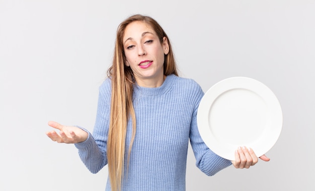 Pretty thin woman holding an empty clean dish