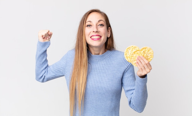 Foto donna abbastanza magra che tiene una torta dietetica di riso