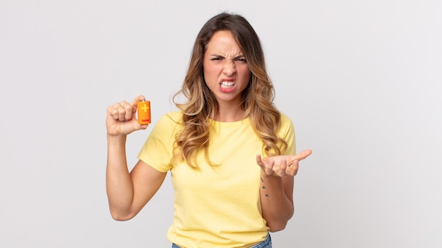 Pretty thin woman looking angry, annoyed and frustrated and holding batteries