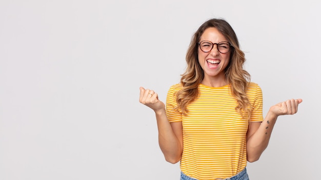 Pretty thin woman looking extremely happy and surprised, celebrating success, shouting and jumping