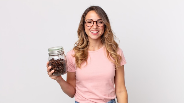 Pretty thin woman looking happy and pleasantly surprised and holding a coffee beans bottle