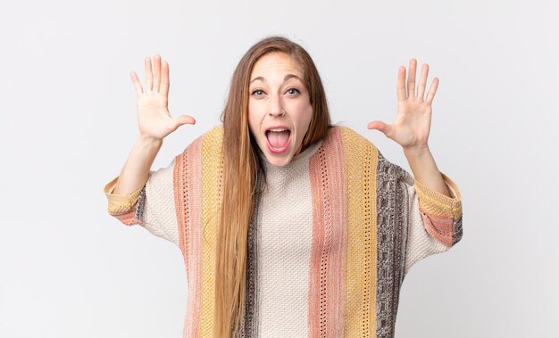 Pretty thin woman screaming in panic or anger, shocked, terrified or furious, with hands next to head