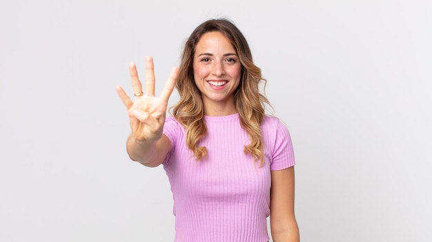 Pretty thin woman smiling and looking friendly, showing number four or fourth with hand forward, counting down