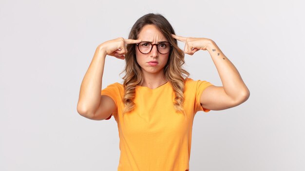 Foto donna piuttosto magra con uno sguardo serio e concentrato, che fa brainstorming e pensa a un problema impegnativo