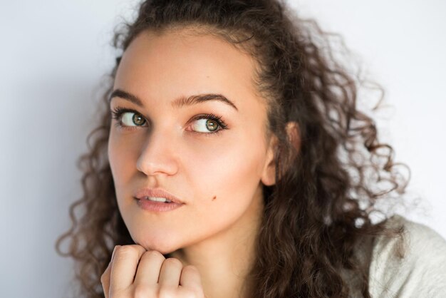 Pretty thinking young woman looking at the one side Closeup portrait