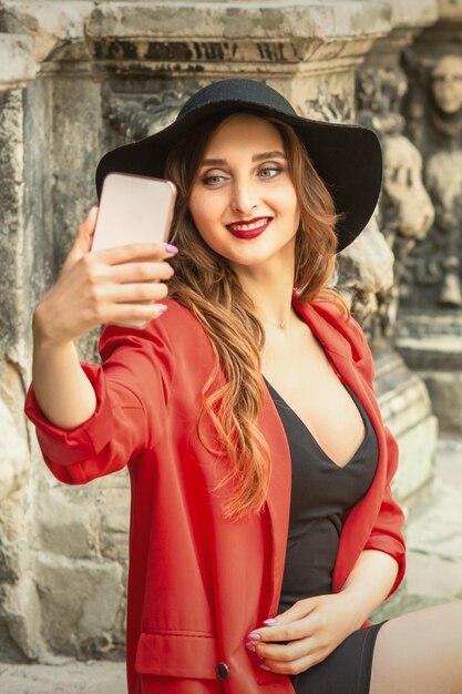 Pretty tourist girl is taking a selfie.