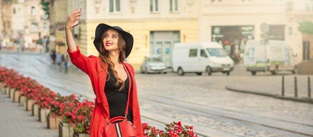 Pretty tourist girl is taking a selfie.