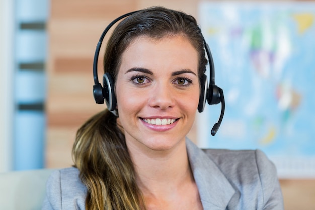 Pretty travel agent smiling at camera in the office