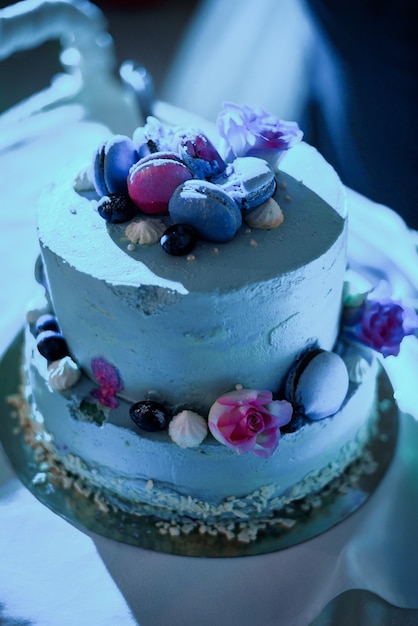 Pretty wedding cake made of pink and blue macaroons stands on steel dish