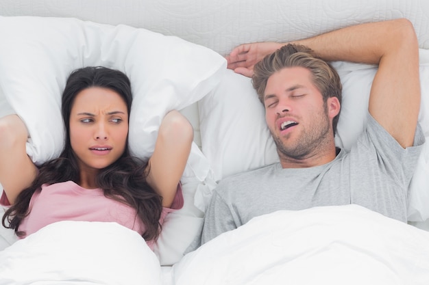 Pretty woman annoyed by the snoring of her husband