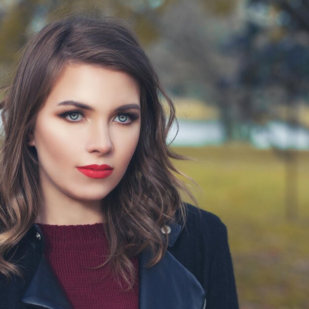 Pretty woman in autumn park closeup portrait