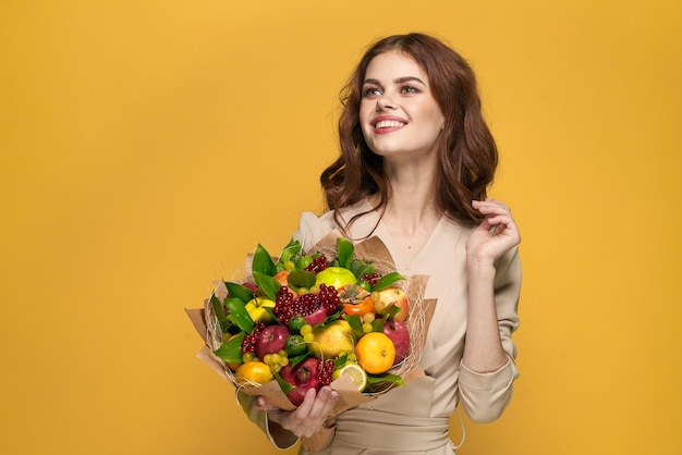 Pretty woman beige coat fruit bouquet in hands present isolated background