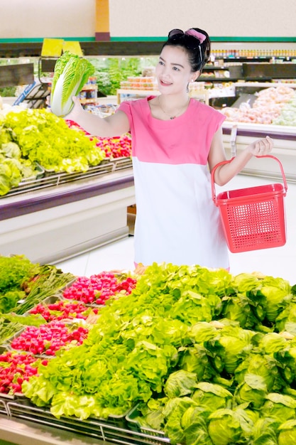 Pretty woman choosing a fresh vegetable