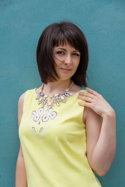 Pretty woman in the city summer posing near an old colorful wall